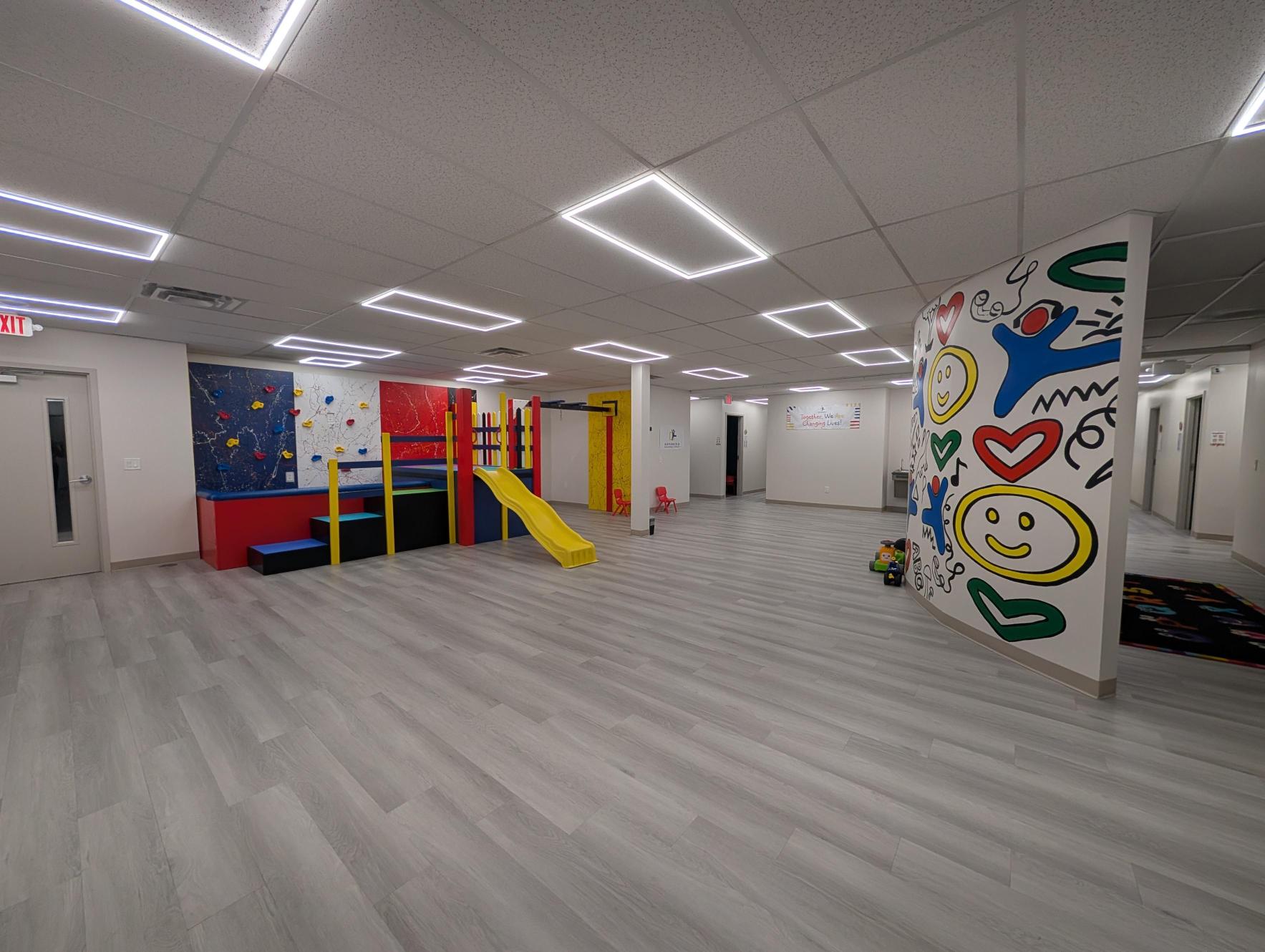 ABT Center — gym with slide, climbing wall, and mural